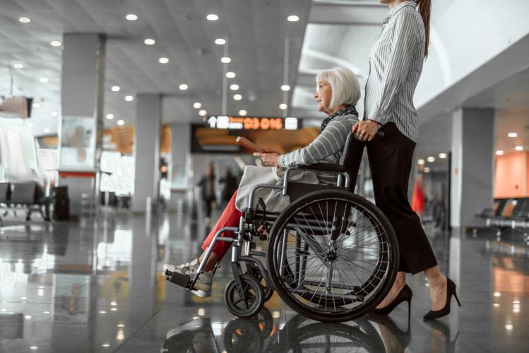 A wheelchair user passenger is being pushed in an airport
