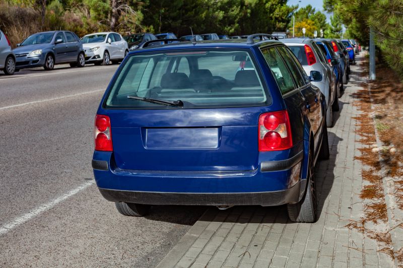 A number of cars are parked on a pavement, blocking access for wheelchair users.