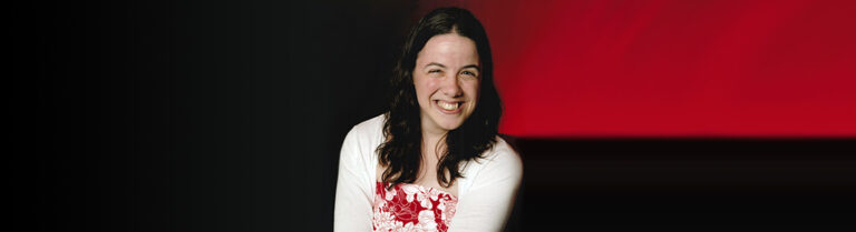 Aideen Blackborough smiling and wearing a red and white dress
