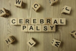 The words cerebral palsy on scrabble tiles with random letters around the words