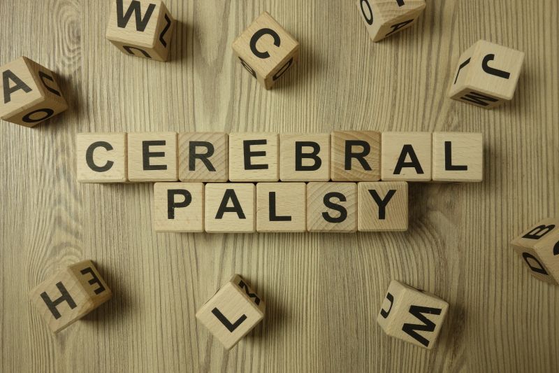 The words cerebral palsy on scrabble tiles with random letters around the words