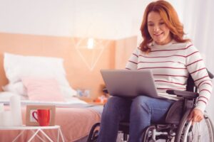 Wheelchair user working on a laptop while managing cerebral palsy