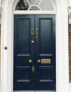 “Blue double doors with intercom entry on a city street, highlighting access barriers.”