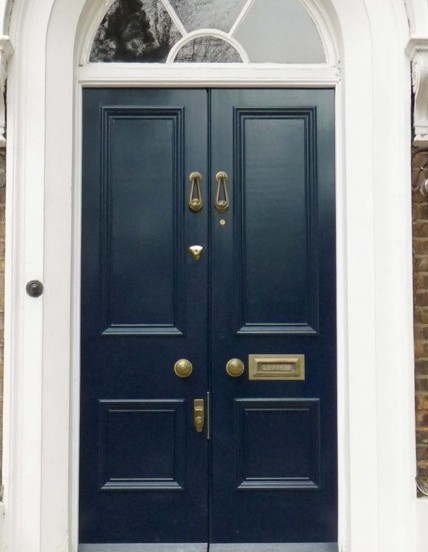“Blue double doors with intercom entry on a city street, highlighting access barriers.”